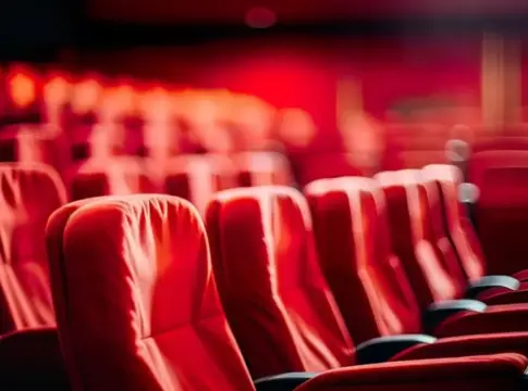 Butacas rojas en una sala de cine Filas de butacas rojas en una sala de cine con iluminación tenue.