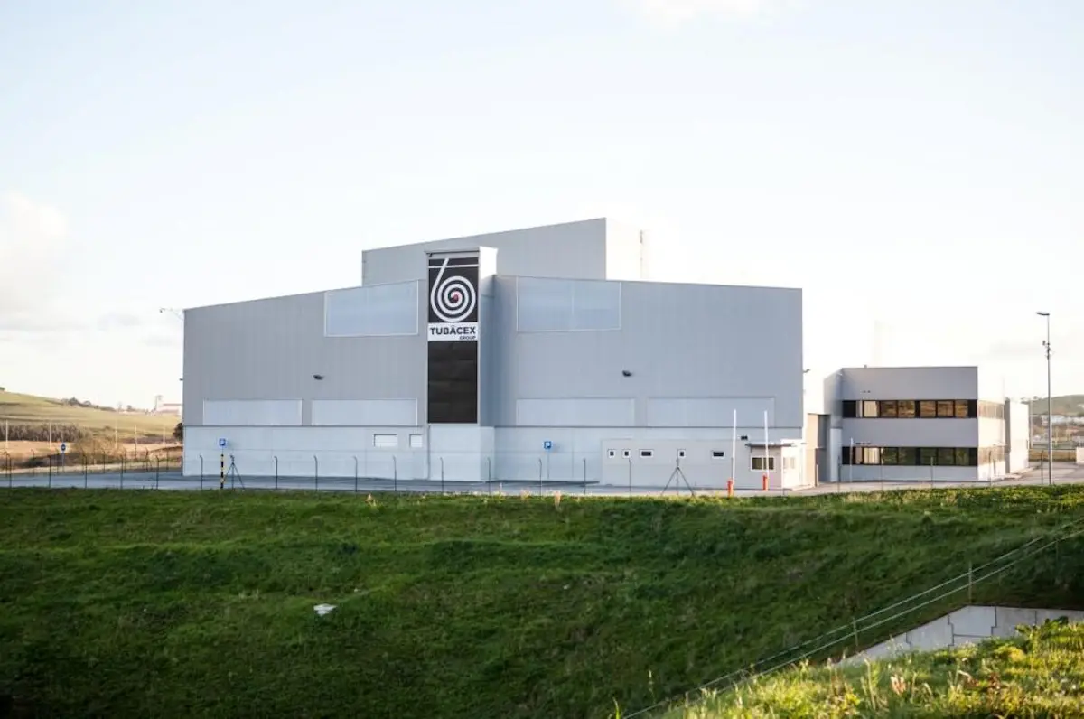 Edificio industrial de Tubacex con fachada gris, logo visible y zona verde delante.