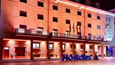 Fachada de Móstoles iluminada de naranja Fachada de un edificio de Móstoles iluminada de naranja durante la noche
