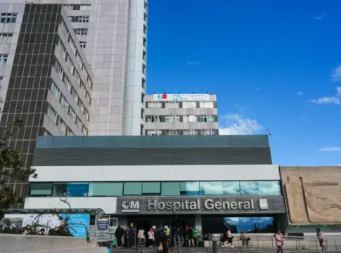 Fachada de un hospital general Fachada del Hospital General con varios edificios y personas en la entrada.