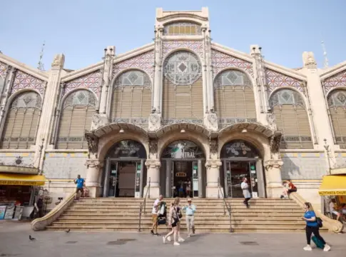 Fachada del Mercado Central Fachada ornamentada del Mercado Central, con puestos exteriores y peatones en la entrada.