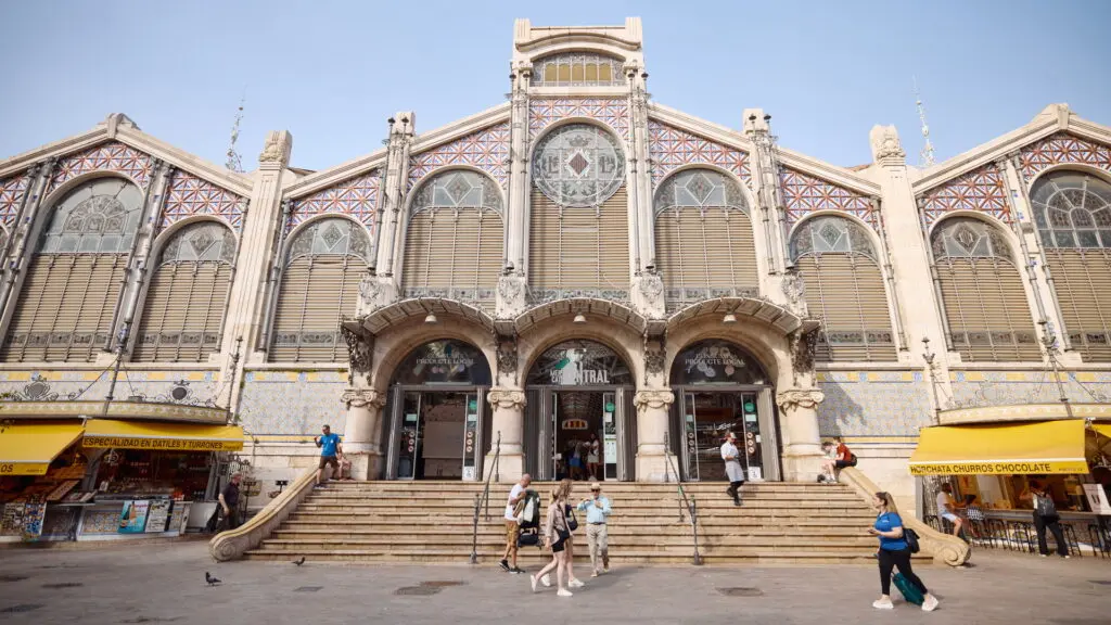 Fachada del Mercado Central Fachada ornamentada del Mercado Central, con puestos exteriores y peatones en la entrada.
