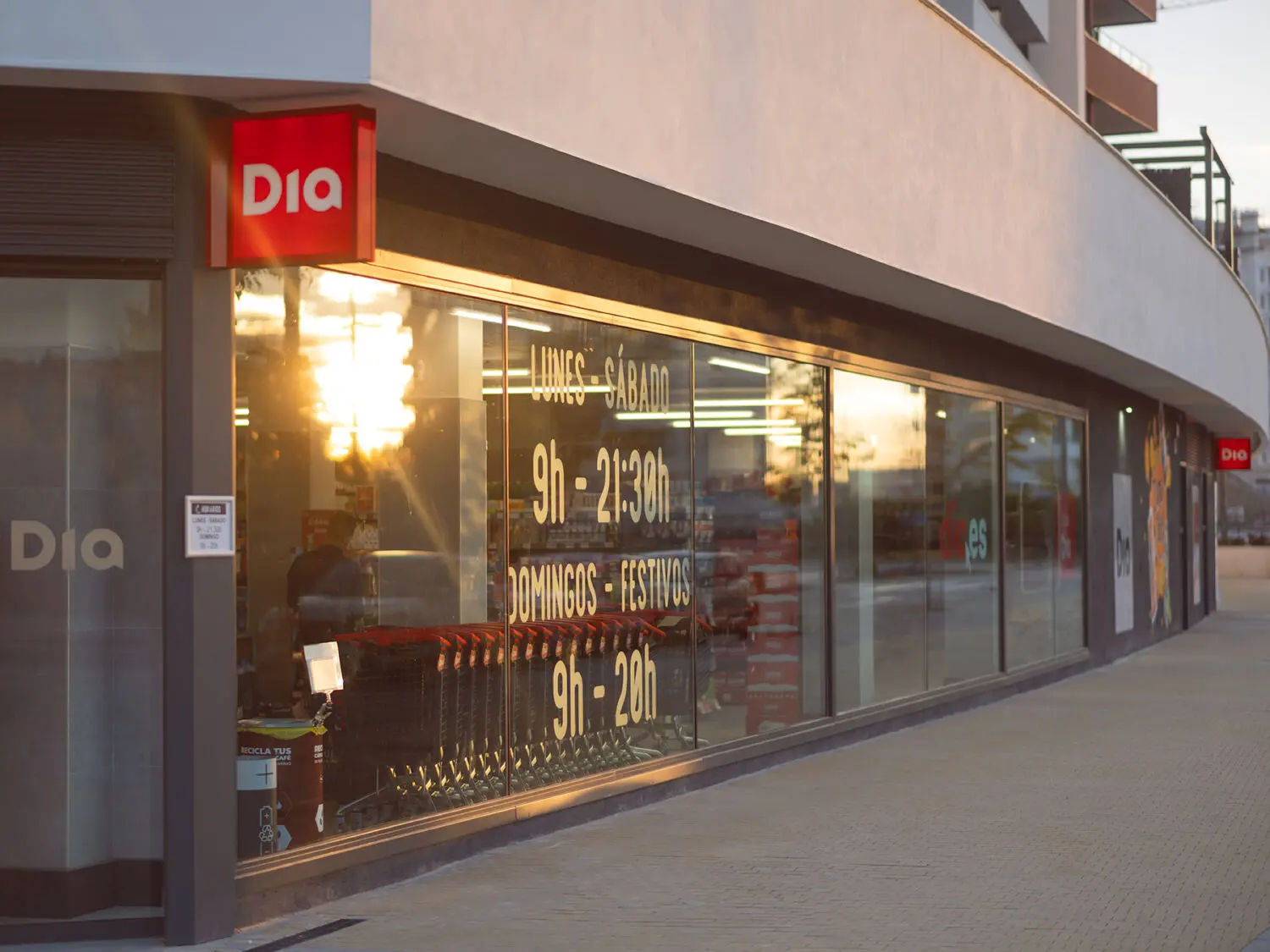 Fachada de un supermercado Dia Fachada de un supermercado Dia con escaparates y carros de compra al atardecer
