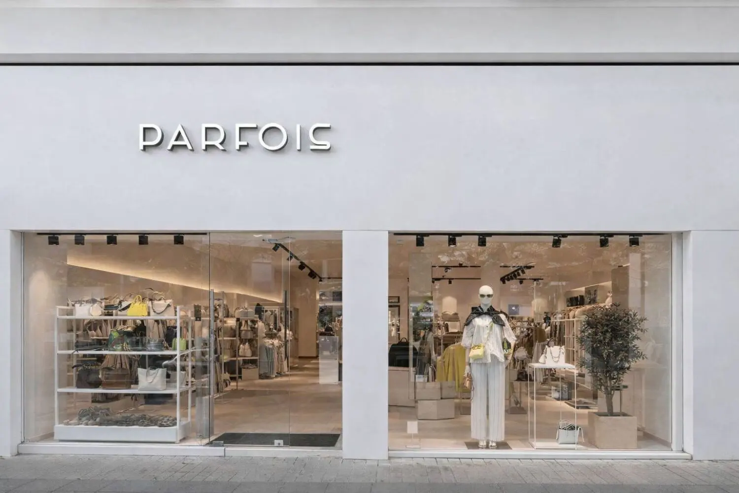Fachada de una tienda Parfois con escaparate de accesorios, ropa y maniquí.