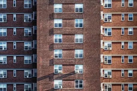 Fachadas de edificios de ladrillo Fachadas de varios edificios de ladrillo, con numerosas ventanas distribuidas en filas.