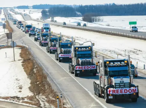 Camiones con pancartas en carretera nevada protesta camioneros Italia