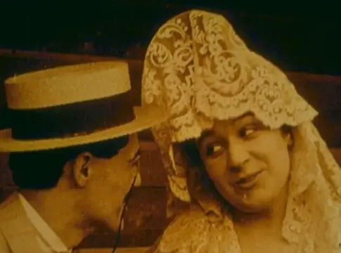 Hombre y mujer en un fotograma antiguo Fotograma de apariencia antigua con un hombre de sombrero y una mujer con tocado ornamentado