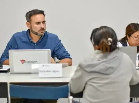 Personas en una selección de Freshuelva Personas sentadas frente a una mesa durante una entrevista, con un portátil de Freshuelva.