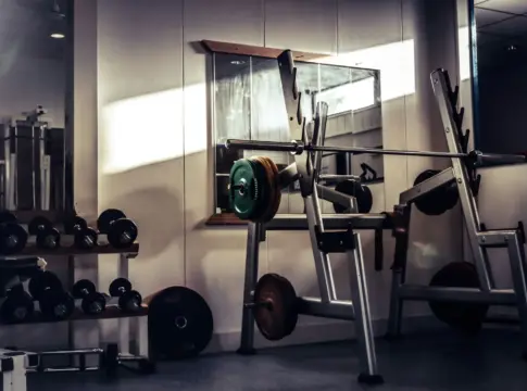 Barra y mancuernas en un gimnasio rutina de fuerza tres días