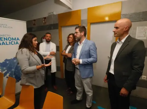 Grupo junto al cartel de Xenoma Galicia Varias personas conversan junto a un cartel del proyecto Xenoma Galicia en un hospital.