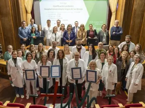 Grupo con certificados enmarcados Grupo de personas posa en un salón; varias sostienen certificados enmarcados.