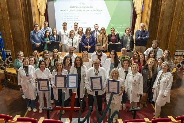 Grupo con certificados enmarcados Grupo de personas posa en un salón; varias sostienen certificados enmarcados.