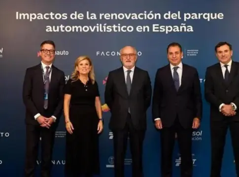 Grupo ante el fondo del informe Cinco personas posan ante un fondo sobre la renovación del parque automovilístico en España.