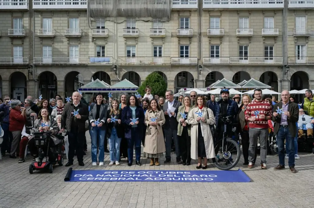 Grupo de personas posa junto a una pancarta por el Día del Daño Cerebral Adquirido