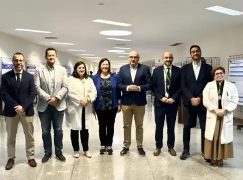 Grupo posa ante carteles científicos Grupo de ocho personas posa ante paneles con carteles científicos en un pasillo.