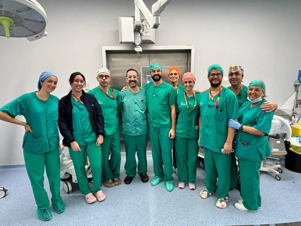 Grupo de personas con ropa quirúrgica posa junto a equipos en un quirófano