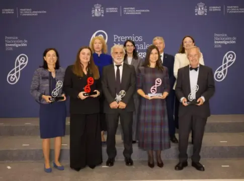 Grupo posa con premios de investigación Grupo de personas posa con trofeos ante el fondo de los Premios Nacionales de Investigación 2026