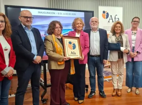 Grupo posa con una placa de AFA Ocho personas posan en un acto junto a una placa enmarcada con el logotipo de AFA.