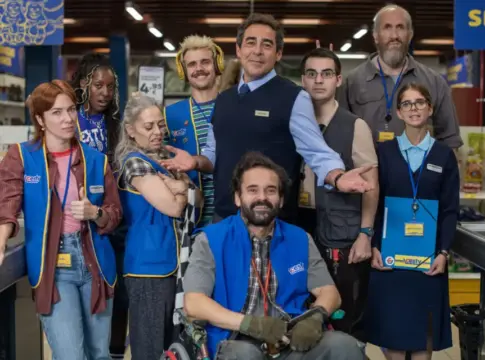 Personas posan en un supermercado Grupo posa en un supermercado; varias personas llevan chalecos azules y acreditaciones.