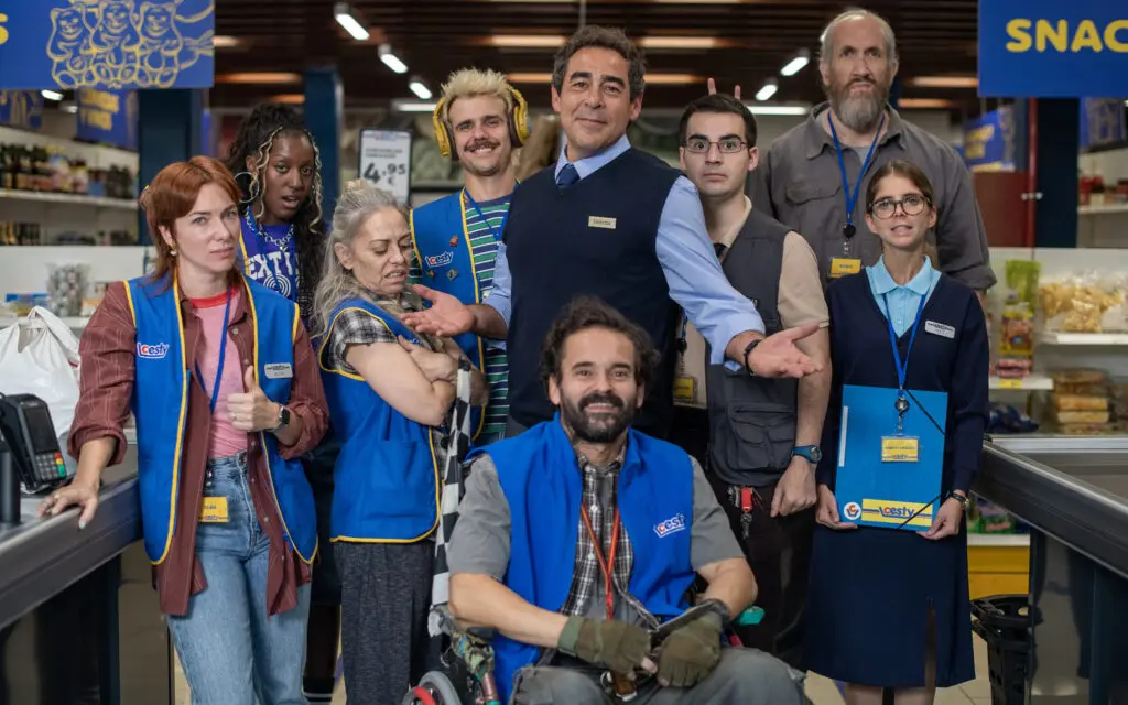 Personas posan en un supermercado Grupo posa en un supermercado; varias personas llevan chalecos azules y acreditaciones.
