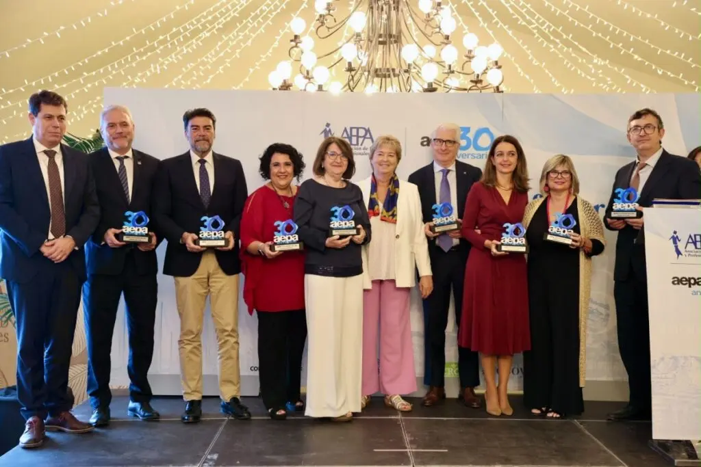 Grupo posa con reconocimientos de AEPA Grupo de personas posa con reconocimientos de AEPA durante su aniversario de 30 años.