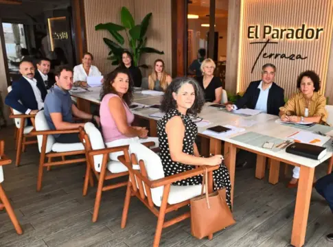 Grupo reunido alrededor de una mesa Grupo de personas reunido alrededor de una mesa con documentos y cuadernos.