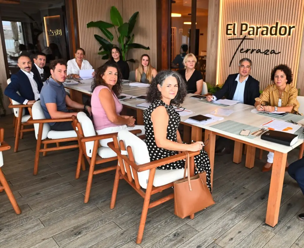 Grupo de personas reunido alrededor de una mesa con documentos y cuadernos.