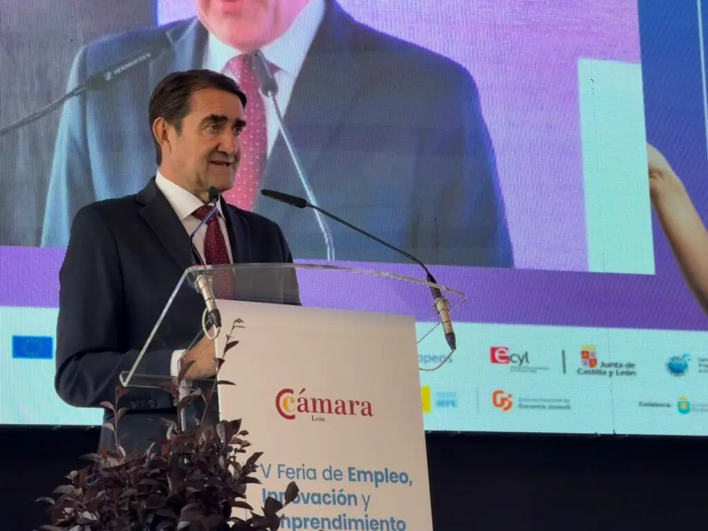 Intervención ante el atril de la feria Hombre con traje habla ante un atril con el cartel de la V Feria