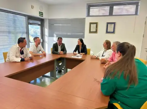 Reunión alrededor de una mesa Varias personas sentadas alrededor de una mesa durante una reunión en una sala.