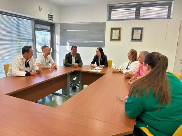 Reunión alrededor de una mesa Varias personas sentadas alrededor de una mesa durante una reunión en una sala.