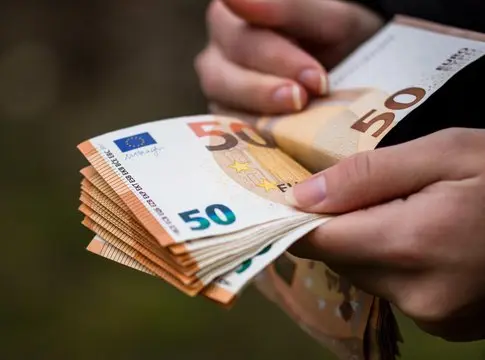 Manos contando billetes de euro Manos cuentan varios billetes de euro, entre ellos uno de 50 euros.