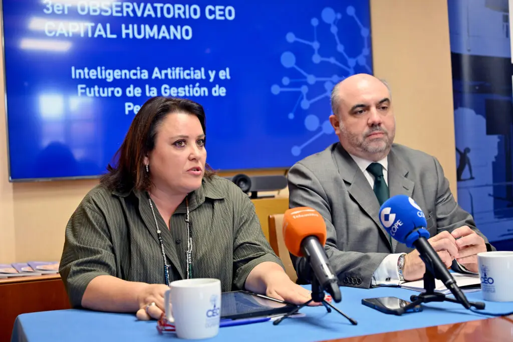 Dos personas sentadas ante micrófonos con una pantalla sobre inteligencia artificial y gestión de personas