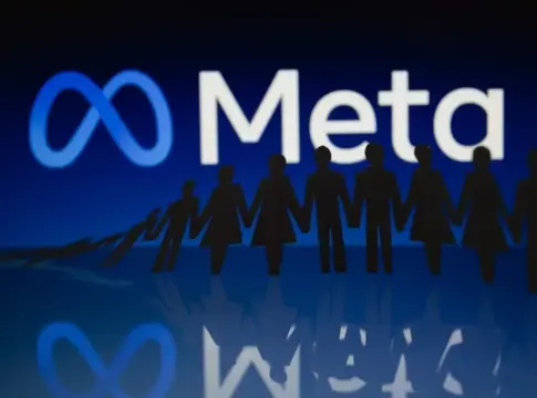 Logotipo de Meta y figuras silueteadas Logotipo de Meta iluminado detrás de siluetas negras de figuras unidas sobre una superficie reflectante.