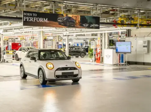 Automóvil MINI en una planta de producción Automóvil MINI blanco en una planta de producción con otros vehículos