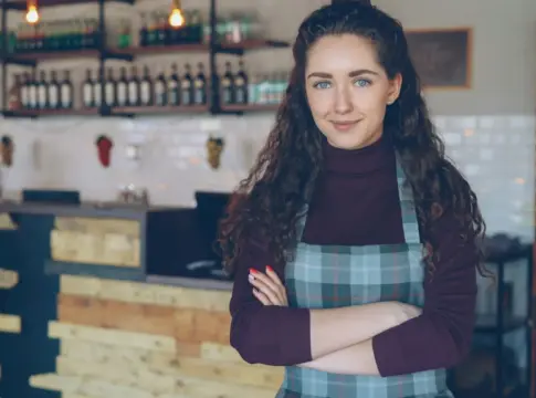 Mujer con delantal en una cafetería mujeres autónomas