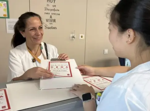Documentos de una campaña de donación de sangre Dos mujeres en una mesa manipulan documentos de una campaña de donación de sangre.