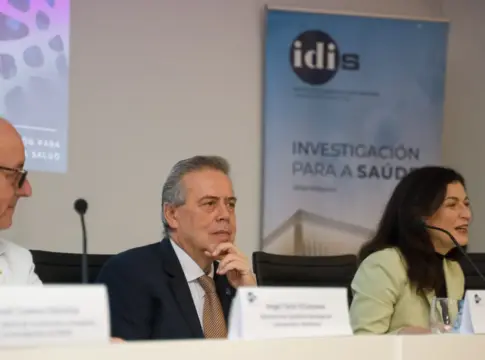Panel de una jornada de investigación sanitaria Tres personas sentadas en una mesa durante una jornada sobre investigación sanitaria.