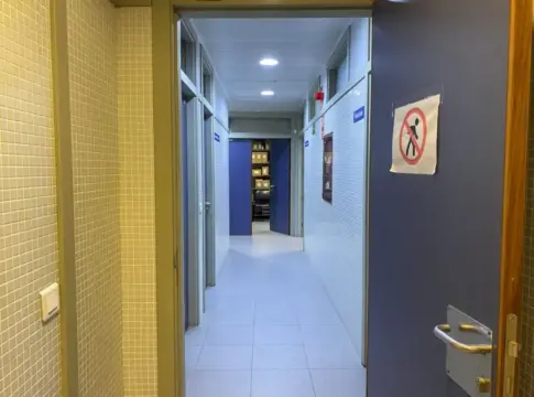 Pasillo interior con señal de acceso prohibido Pasillo interior despejado con puertas abiertas y una señal de paso prohibido.
