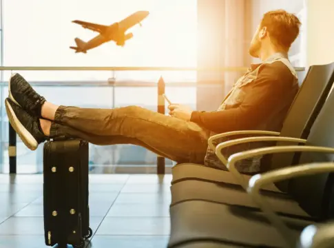 Persona en sala de espera con maleta IA industria viajes