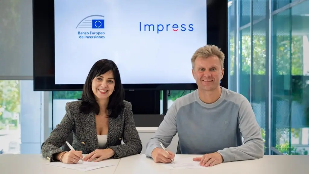Dos personas sentadas ante documentos, bajo los logotipos del Banco Europeo de Inversiones e Impress.