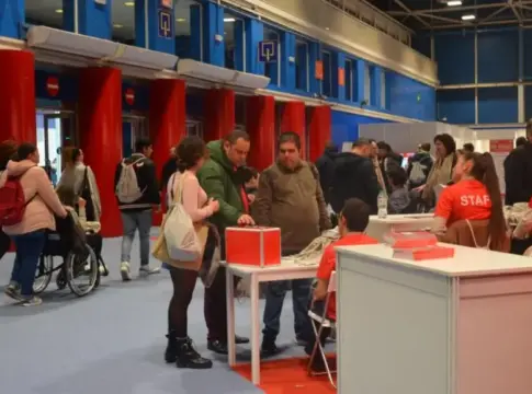 Asistentes en una feria de empleo Personas recorren puestos de una feria de empleo, con una persona usuaria de silla de ruedas.