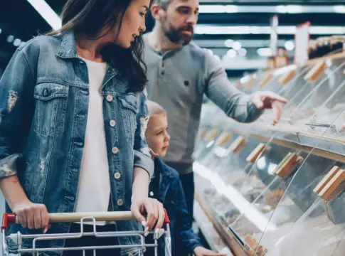 Personas frente a una vitrina de tienda gasto en juguetes de Navidad
