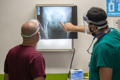 Personas observan una radiografía Dos personas observan una radiografía en una pantalla; una señala la imagen.