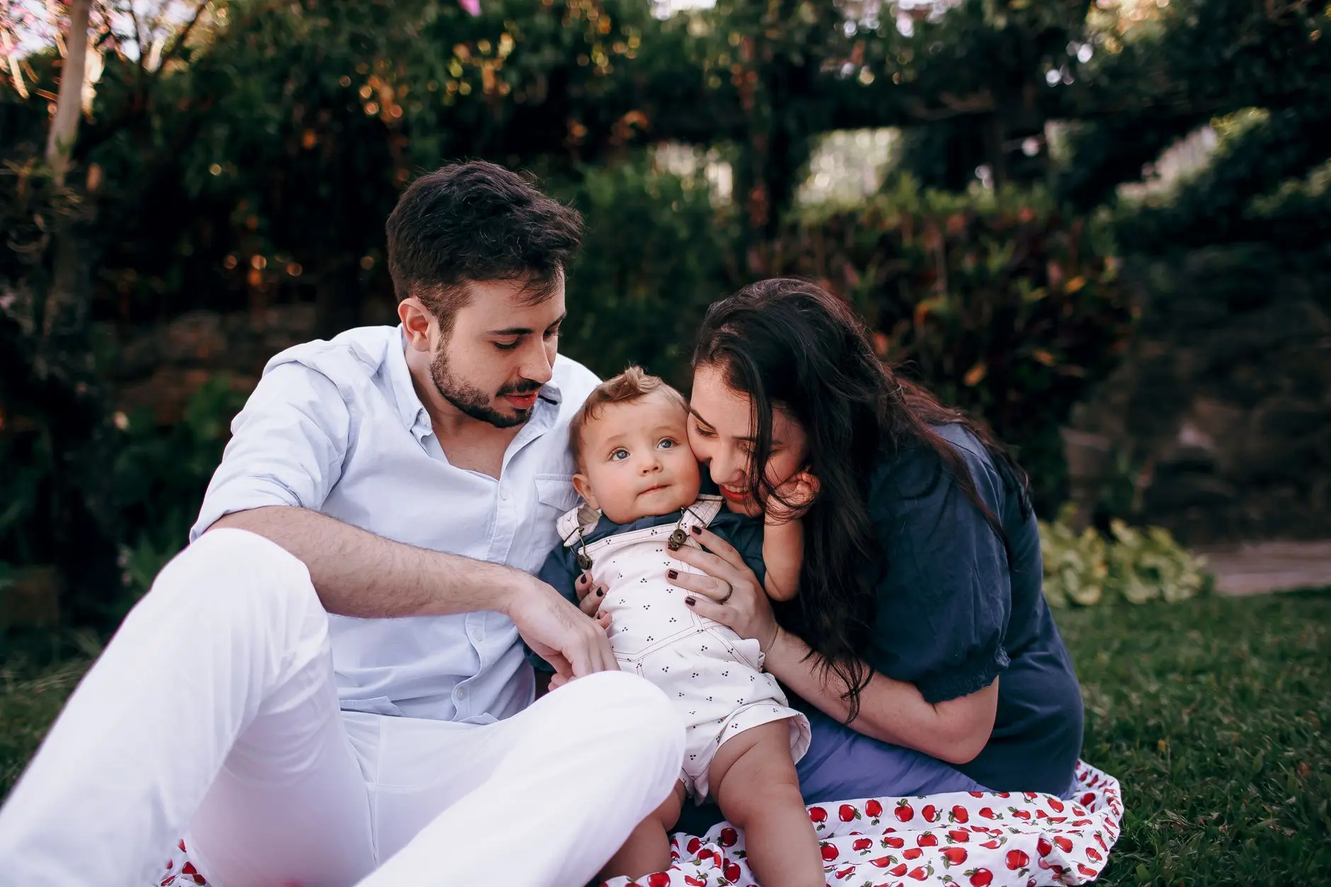 Una familia disfruta de un picnic al aire libre bajo el sol, centrándose en el amor y la alegría compartidos entre ellos.