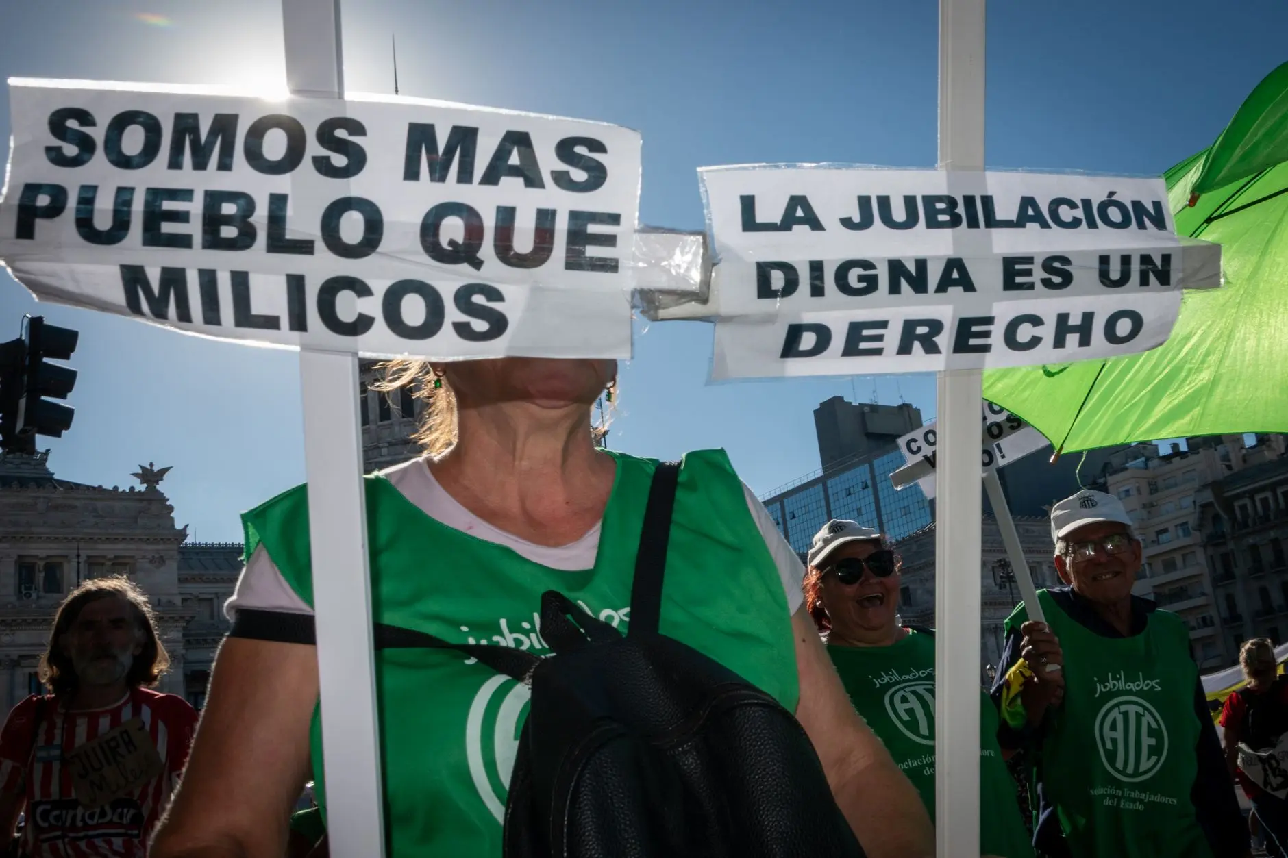 Protesta en la calle en Buenos Aires abogando por derechos de jubilación con carteles visibles y manifestantes.