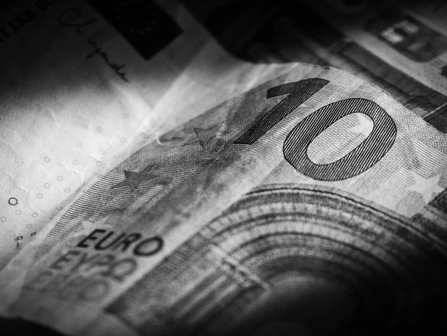Fotografía macro en blanco y negro de un billete de diez euros que resalta sus intrincados detalles y texturas.
