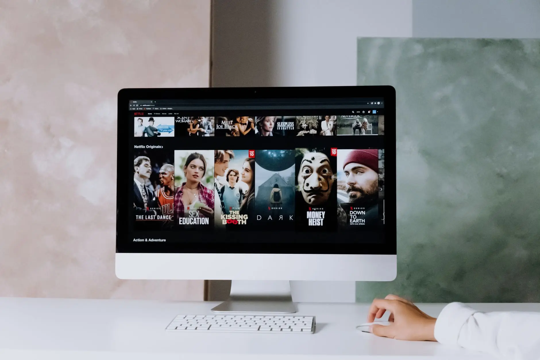 Un espacio de trabajo moderno con una pantalla de escritorio mostrando series populares de streaming en Netflix.