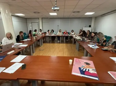 Reunión alrededor de una mesa Personas reunidas alrededor de una mesa en forma de U con documentos y ordenadores portátiles