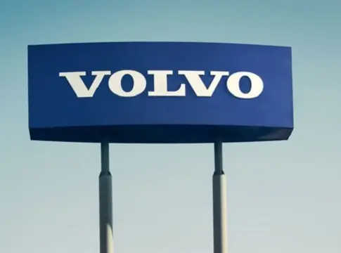 Rótulo azul con el nombre Volvo Rótulo azul con el nombre Volvo en letras blancas, sostenido por dos postes.