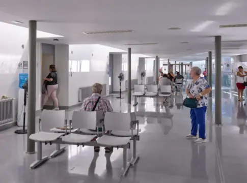 Sala de espera de un centro sanitario Sala de espera de un centro sanitario con varias personas sentadas y de pie.